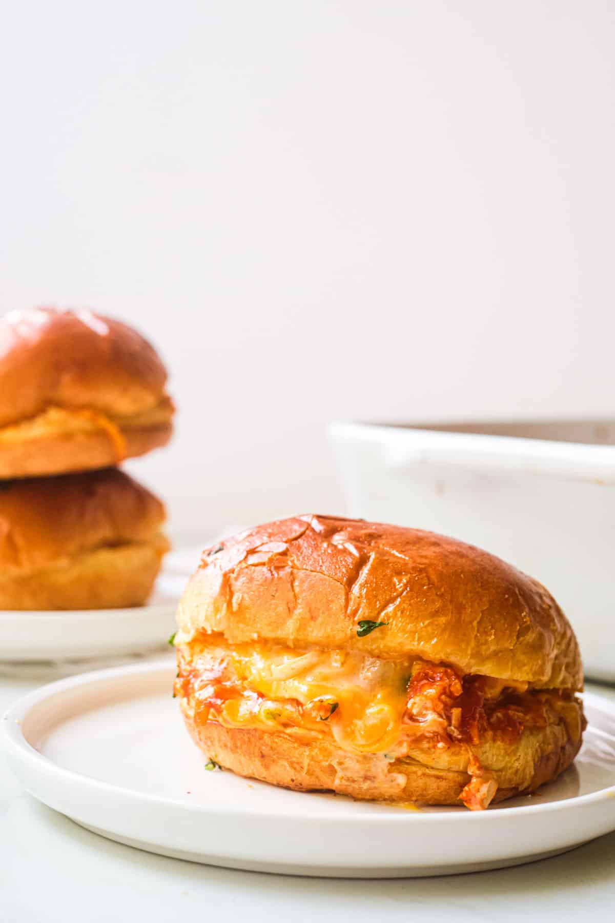 one of the completed buffalo chicken sliders served on a white dinner plate
