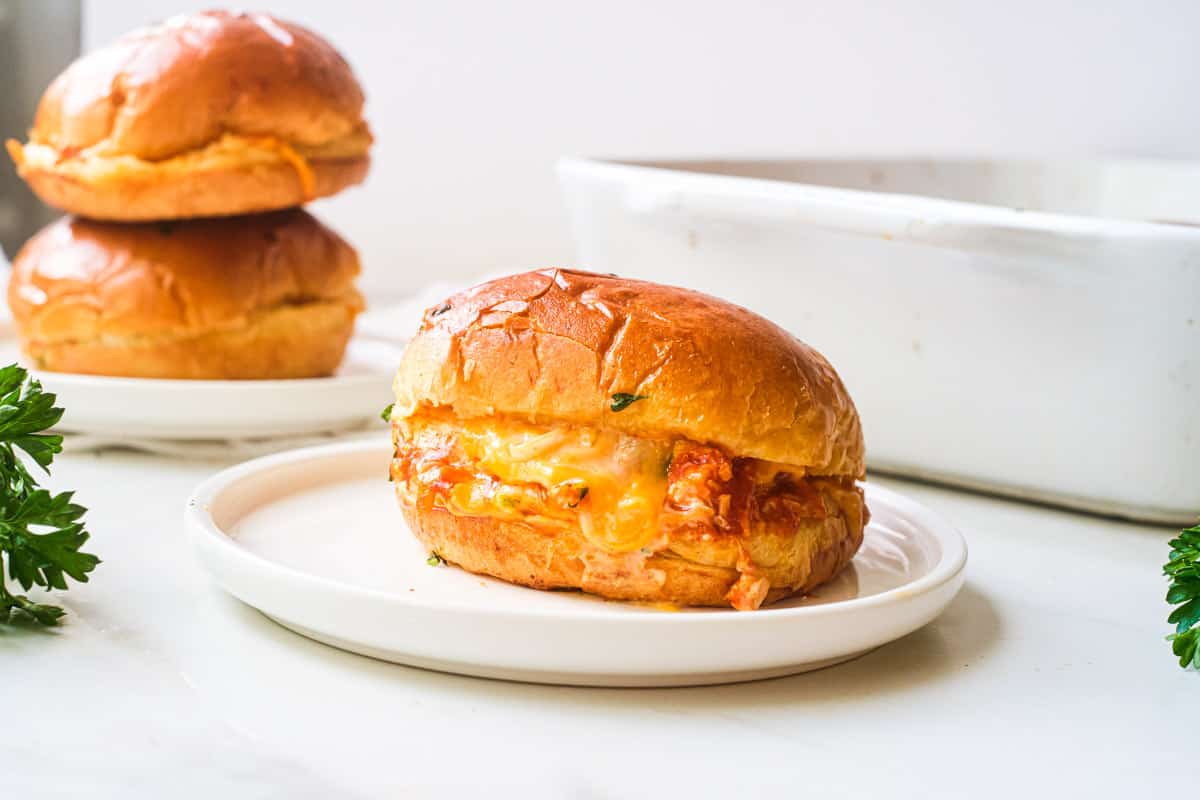 side view of one buffalo chicken slider served on a white plate