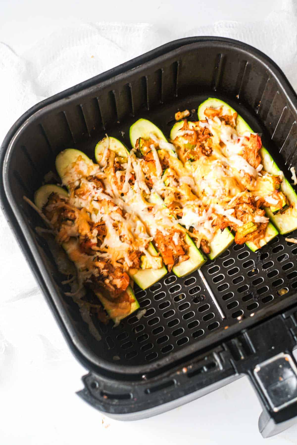 top down view of the buffalo chicken zucchini boats inside the air fryer basket