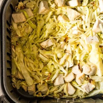 the finished air fryer chicken and cabbage recipe inside the air fryer basket