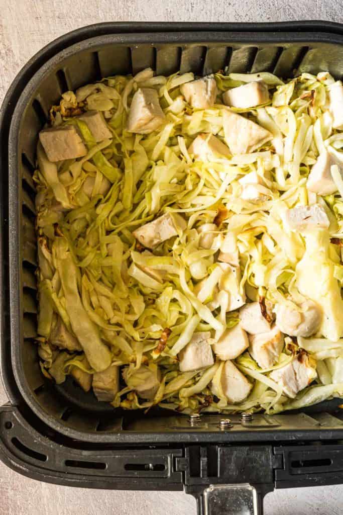 the finished air fryer chicken and cabbage recipe inside the air fryer basket