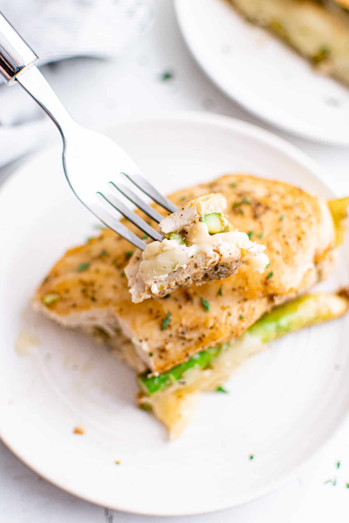 a fork removing one bite of the completed instant pot stuffed chicken breast