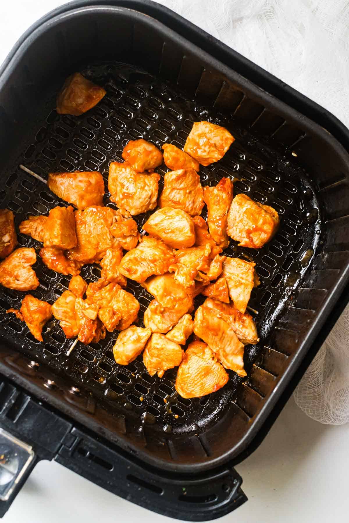 top down view of the cooked buffalo chicken bites inside the air fryer basket