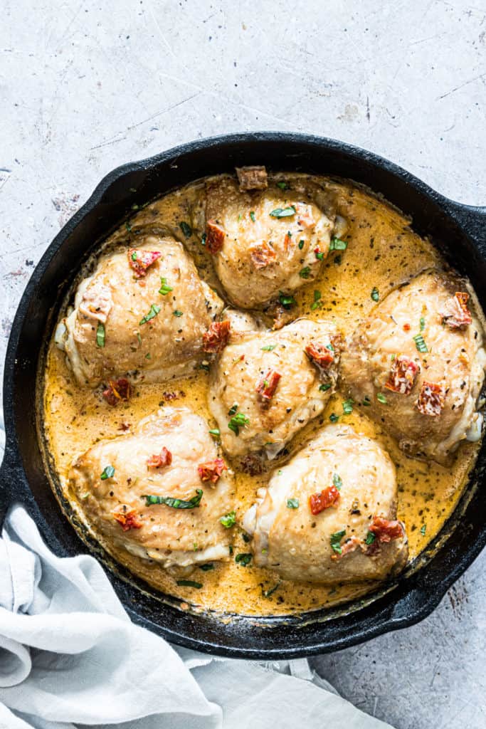 Cooked marry me chicken in a creamy sauce in a skillet with herbs and sundried tomatoes