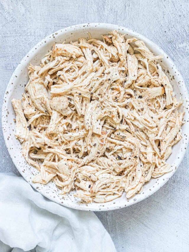the completed instant pot shredded chicken in a serving bowl with a cloth napkin