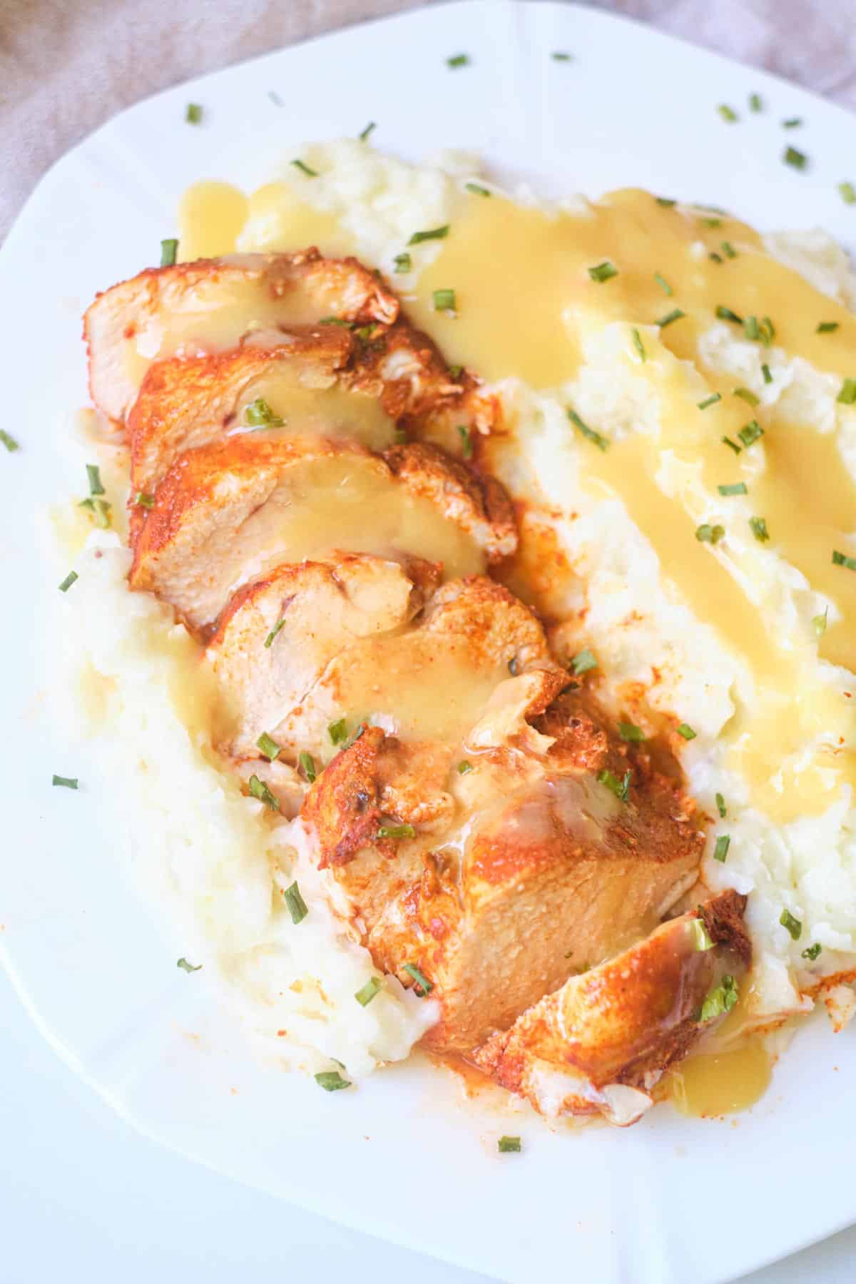 instant pot chicken breast served on a white plate with gravy and mashed potatoes