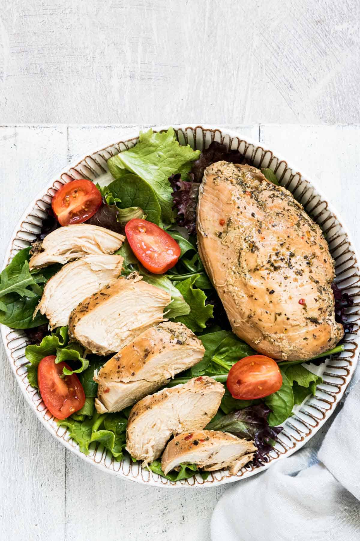 the finished instant pot frozen chicken breast recipe served on top of a green salad