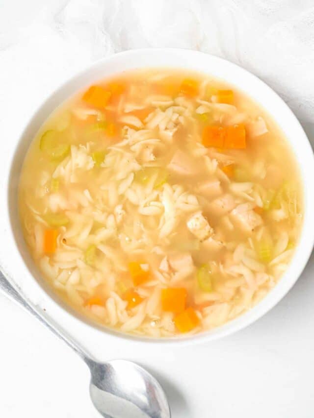 a white bowl filled with instant pot lemon chicken orzo soup