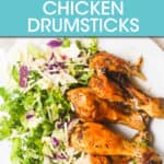 CHICKEN DRUMSTICKS ON A PLATE WITH A SIDE SALAD