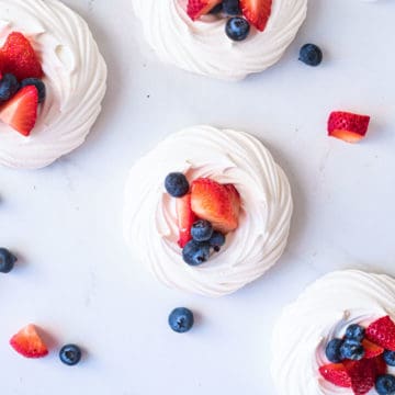 top down view of mini pavlova nests filled with cream and fruit