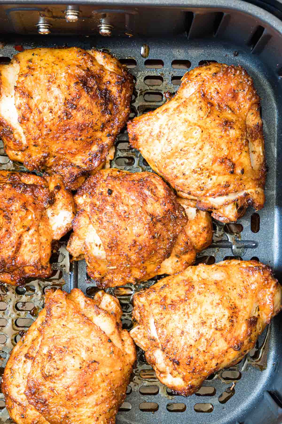 top down view of air fryer chicken thighs inside the air fryer basket