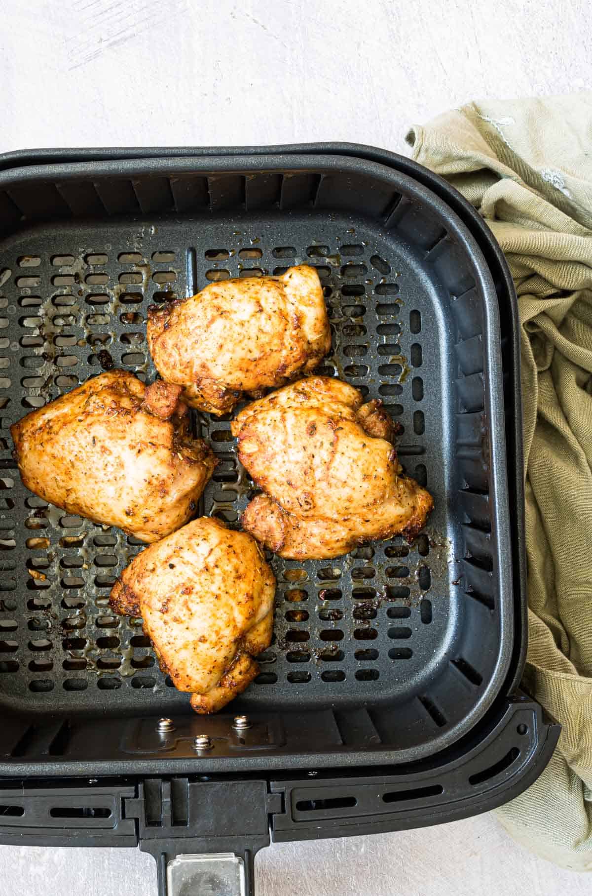 top down view of the completed air fryer boneless chicken thighs inside the air fryer basketd