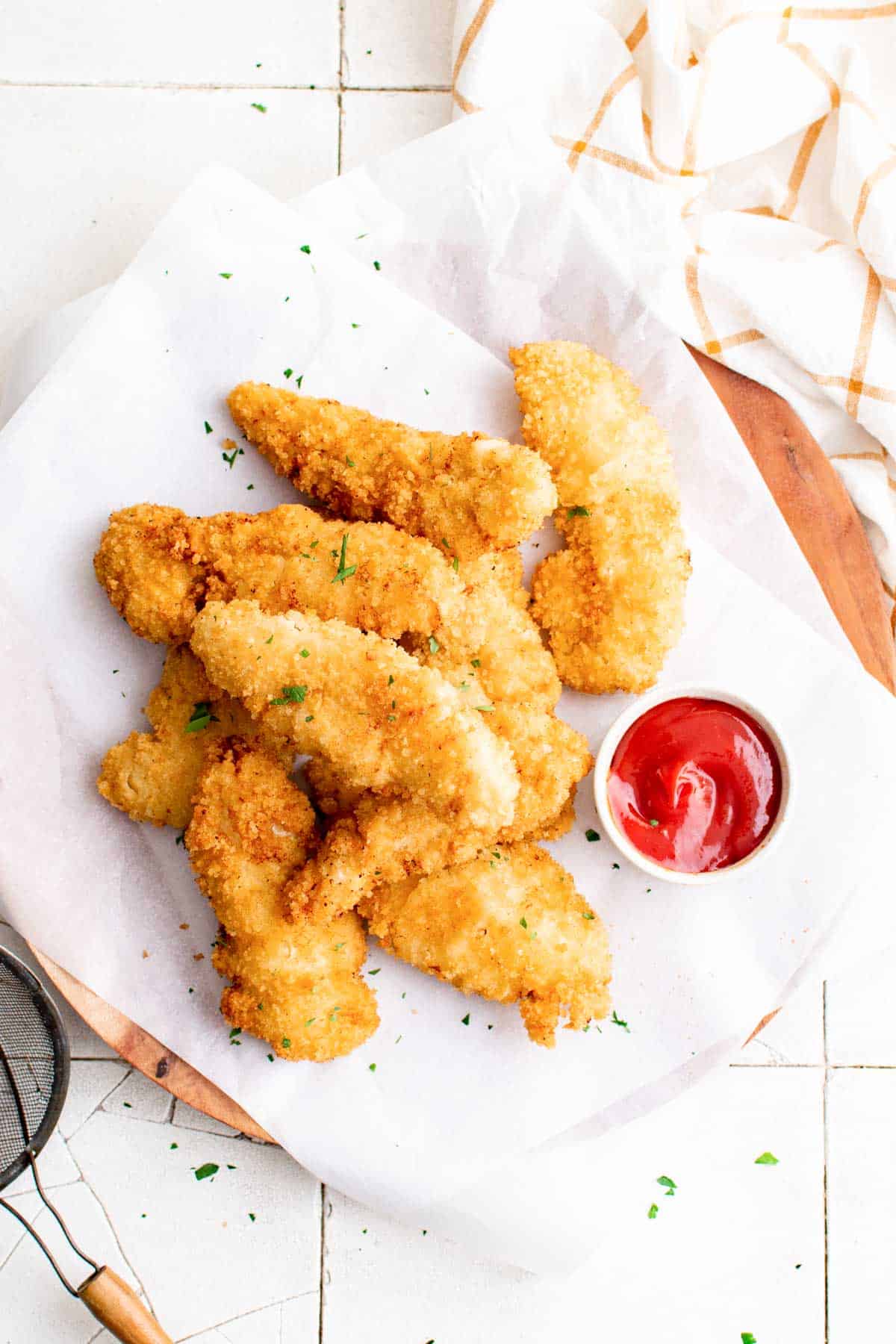 top down view of air fryer chicken tenders served on a white plate