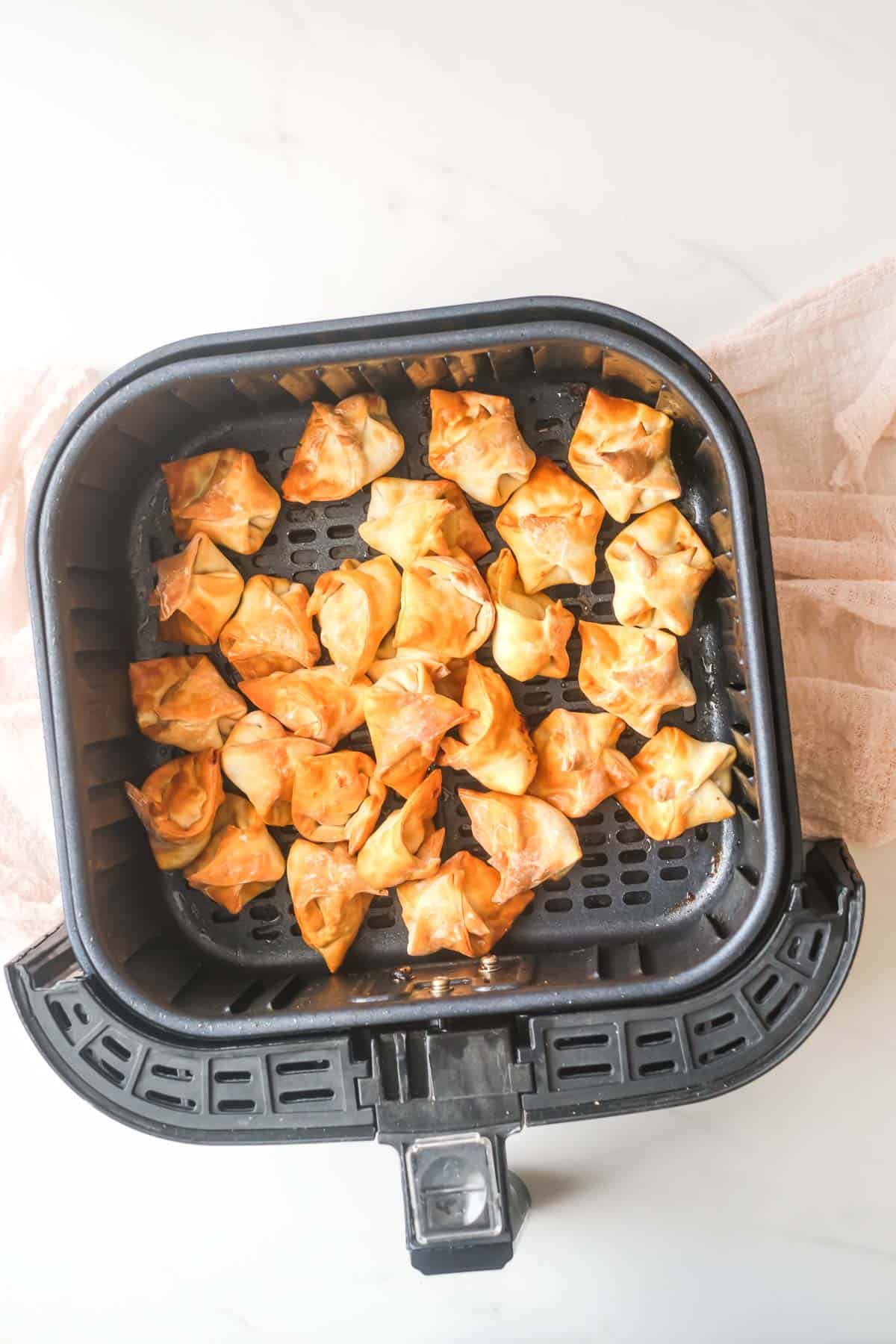 the finished air fryer wontons inside the air fryer basket