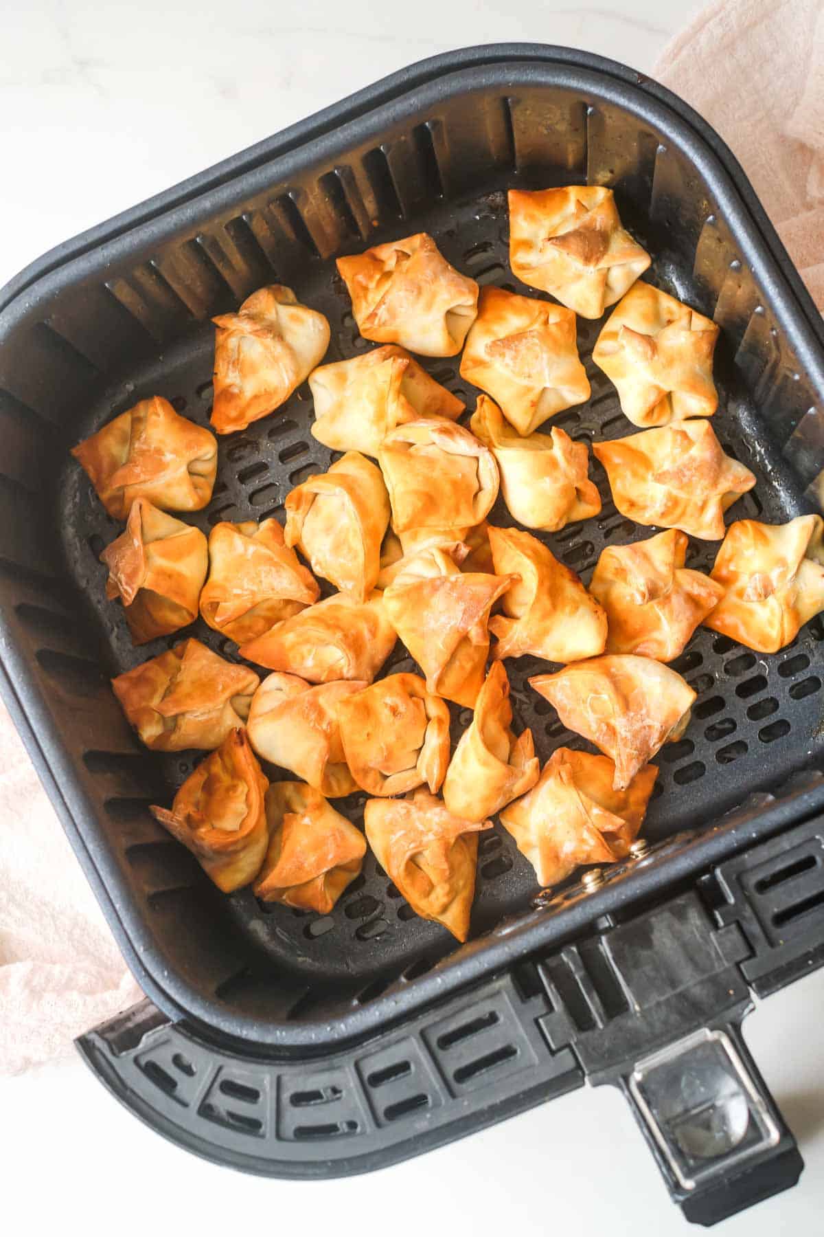 top down view of the air fryer wontons inside the air fryer basket
