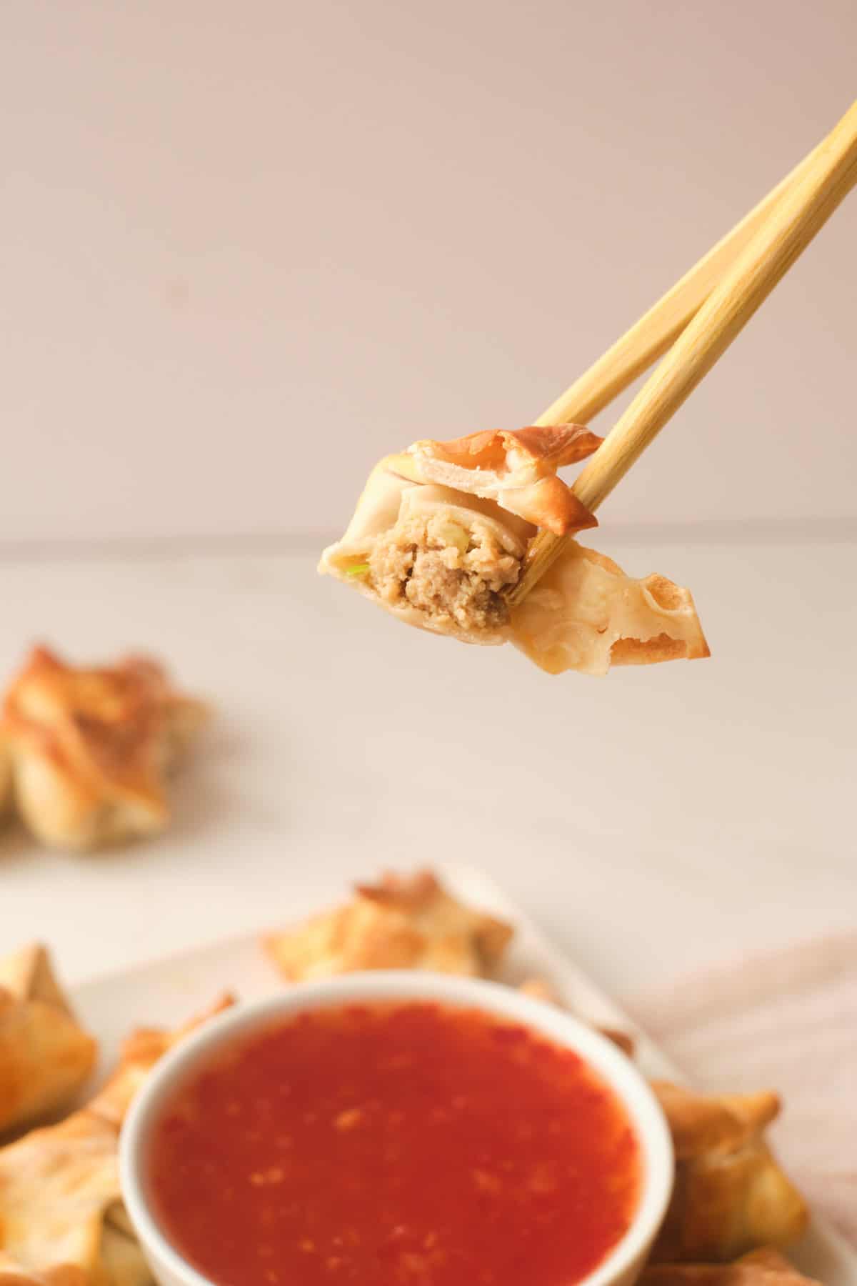 one of the air fryer wontons being dipped into sauce