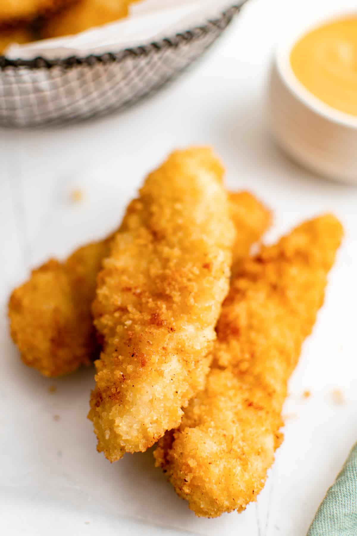 three of the finished buttermilk chicken tenders served with dipping sauce