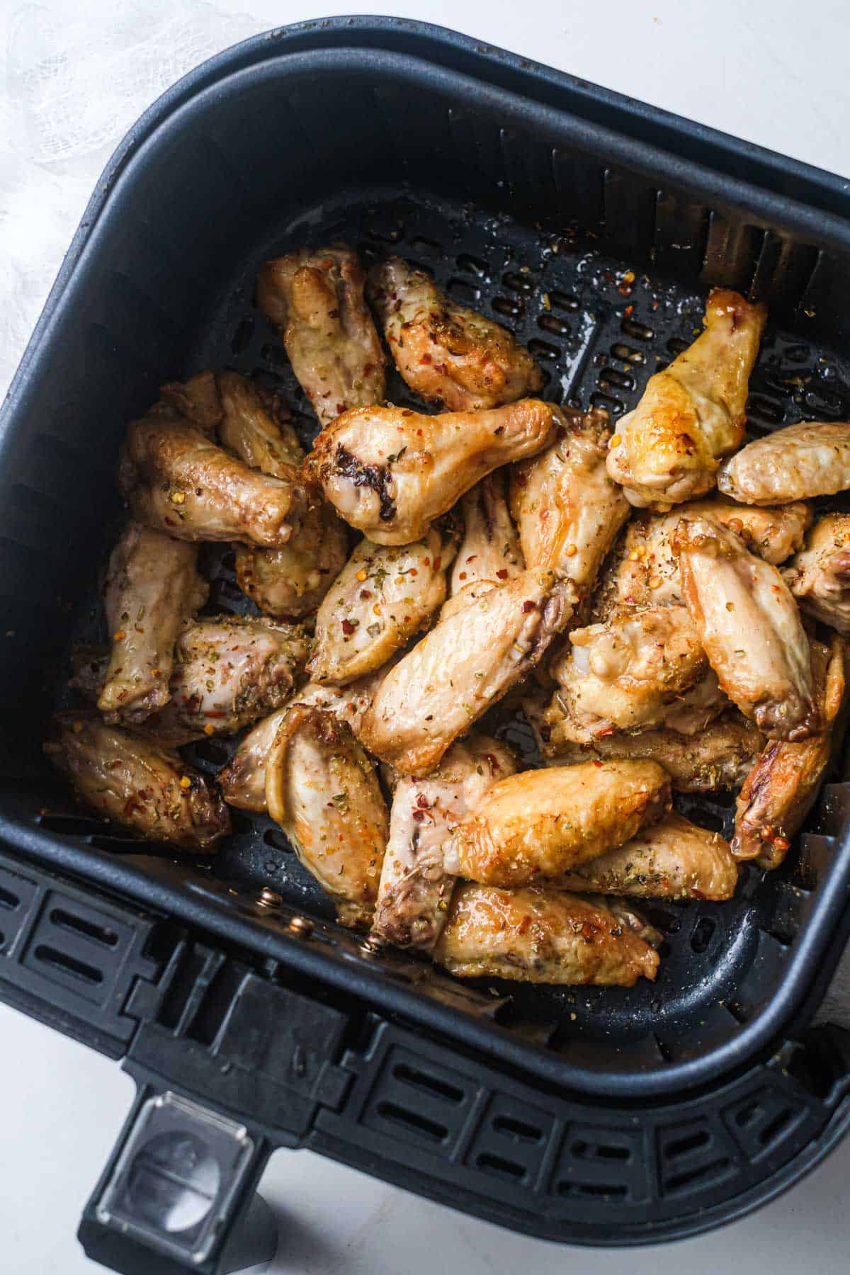 top down view of the cooked cajun wings inside the air fryer basket