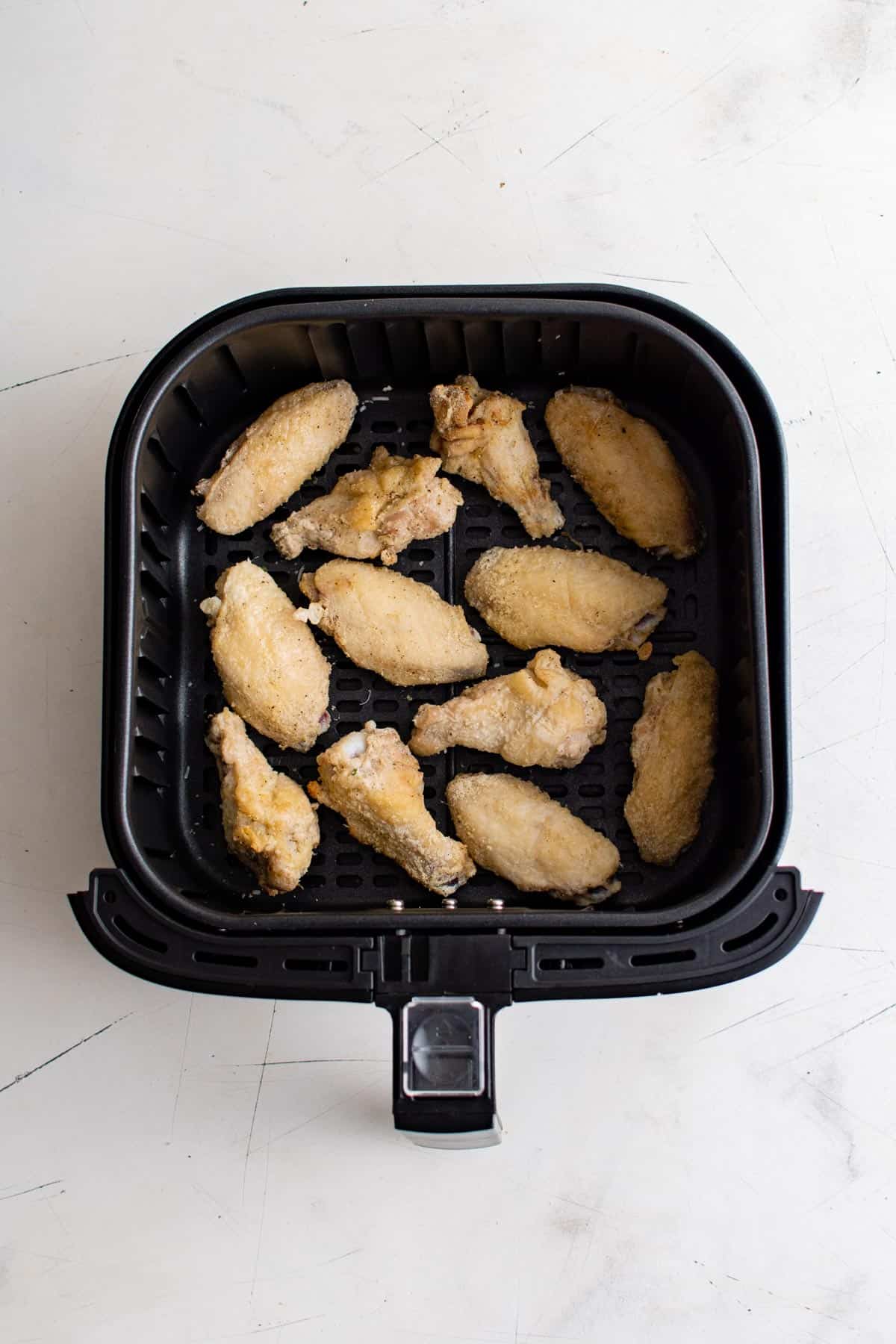 top down view of chicken wings in air fryer basket