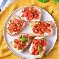 top down view of the bruschetta with cream cheese served on a plate.