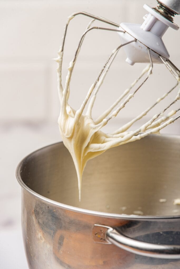 the mixer whisk being removed from the combined dip ingredients.