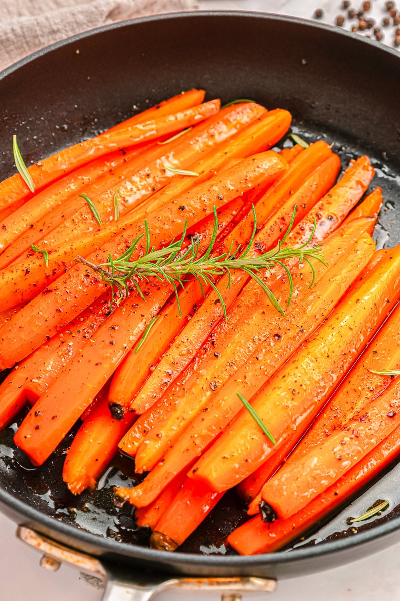 Brown Sugar Glazed Carrot in a skillet with rosemary.